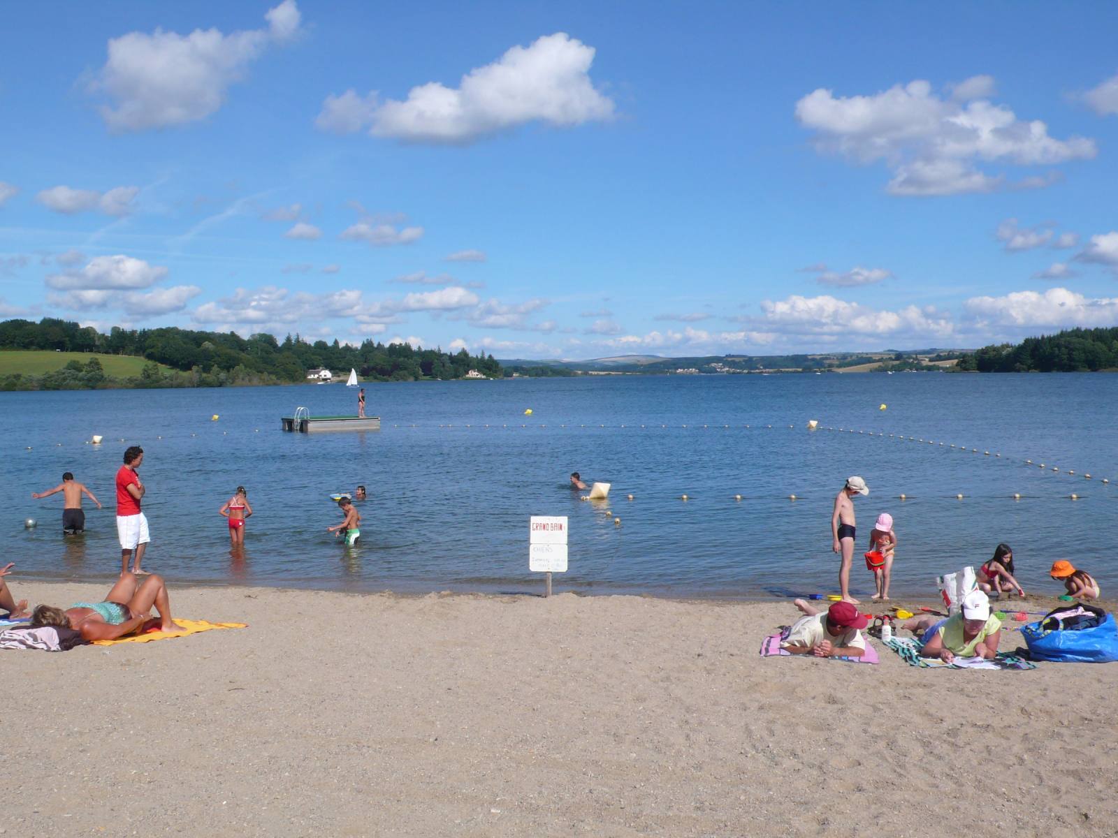 Famille se baignant sur une plage aménagée du lac de Pareloup, sur le plateau du Lévézou en Aveyron